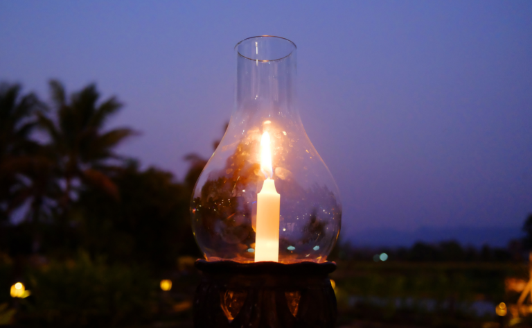 Sommerlicher Tisch mit Kerzen und Blumenkranz bei Dämmerung – Litha Sommersonnenwende Ritual und Feier